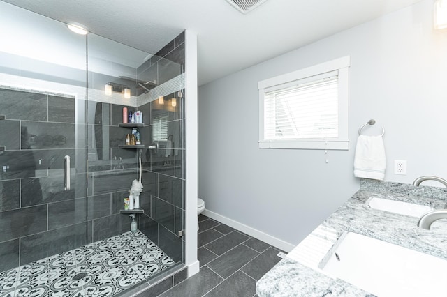 927 Southwell Enclave NE, Byron, MN 55920 - full bathroom with a shower stall, double vanity, toilet, tile patterned floors, and baseboards