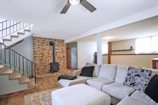 208 Concord St, West Concord, MN 55985 - living area featuring stairs, wood finished floors, ceiling fan, a wood stove, and baseboards