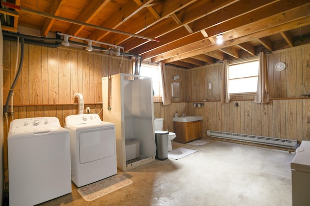 208 Concord St, West Concord, MN 55985 - basement featuring washing machine and clothes dryer, a baseboard heating unit, wood walls, healthy amount of natural light, and a sink