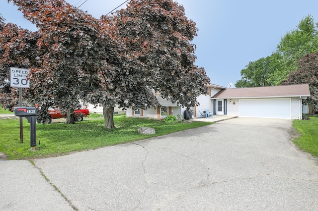 208 Concord St, West Concord, MN 55985 - view of front of house featuring a front yard, an attached garage, and driveway