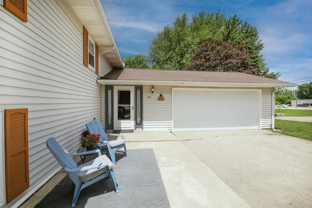 208 Concord St, West Concord, MN 55985 - view of exterior entry with a garage and roof with shingles