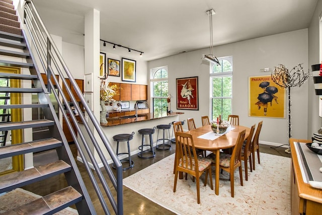 512 Laurel Ave Unit 1, Saint Paul, MN 55102 - dining room featuring rail lighting, stairway, and finished concrete flooring
