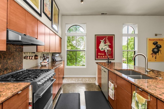 512 Laurel Ave Unit 1, Saint Paul, MN 55102 - kitchen with appliances with stainless steel finishes, under cabinet range hood, brown cabinets, tasteful backsplash, and light stone counters