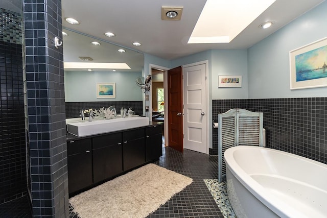 512 Laurel Ave Unit 1, Saint Paul, MN 55102 - bathroom featuring tile walls, a soaking tub, double vanity, recessed lighting, and tile patterned floors