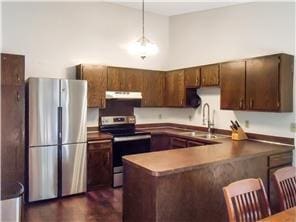 1356 Arden View Dr, Arden Hills, MN 55112 - kitchen featuring stainless steel appliances, under cabinet range hood, a sink, a breakfast bar, and pendant lighting