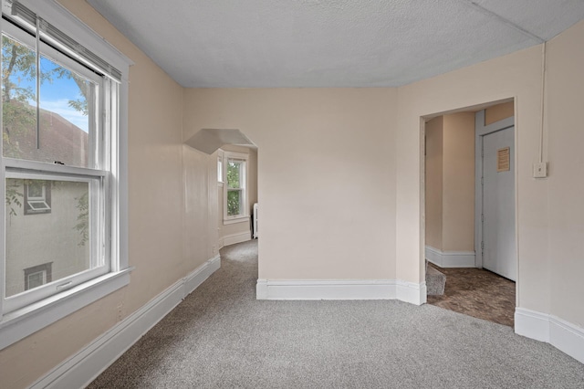 3328 5th Ave S, Minneapolis, MN 55408 - unfurnished room featuring arched walkways, carpet floors, and baseboards