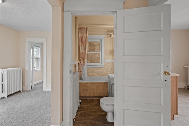 3328 5th Ave S, Minneapolis, MN 55408 - full bath featuring radiator, toilet, a tub, and baseboards