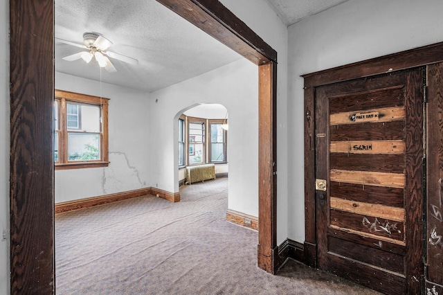 3328 5th Ave S, Minneapolis, MN 55408 - foyer with radiator, carpet flooring, arched walkways, ceiling fan, and baseboards