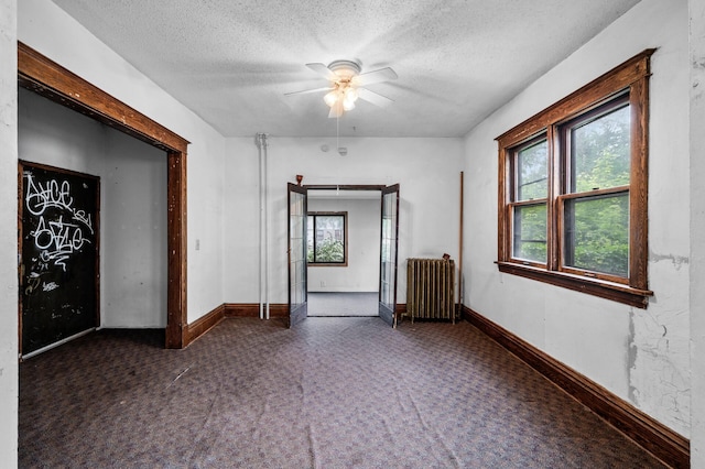 3328 5th Ave S, Minneapolis, MN 55408 - empty room with radiator, a textured ceiling, carpet floors, ceiling fan, and baseboards