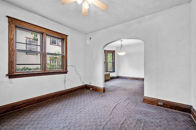 3328 5th Ave S, Minneapolis, MN 55408 - carpeted empty room featuring arched walkways, a textured ceiling, a ceiling fan, and baseboards