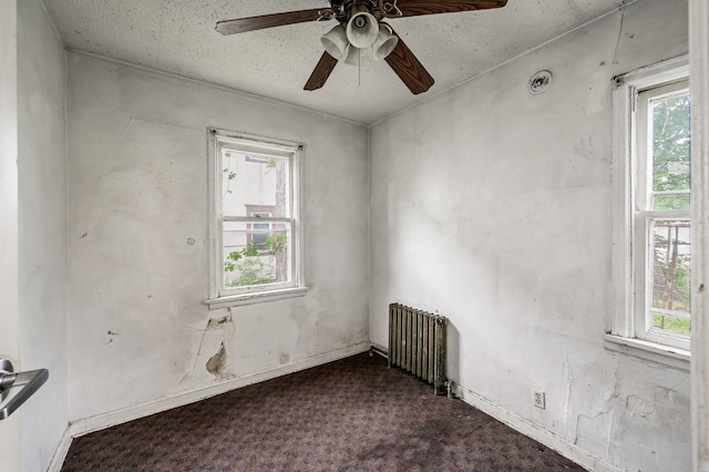 3328 5th Ave S, Minneapolis, MN 55408 - unfurnished room featuring radiator heating unit, dark carpet, a ceiling fan, and baseboards