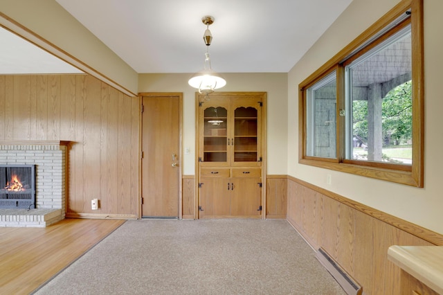 11418 Friar Ln, Minnetonka, MN 55305 - unfurnished dining area featuring a baseboard heating unit, wooden walls, and a brick fireplace