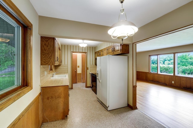 11418 Friar Ln, Minnetonka, MN 55305 - kitchen with white fridge with ice dispenser, a sink, a wainscoted wall, light countertops, and stove