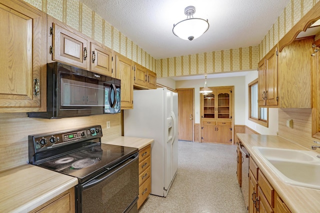 11418 Friar Ln, Minnetonka, MN 55305 - kitchen featuring black appliances, wallpapered walls, light countertops, a sink, and pendant lighting