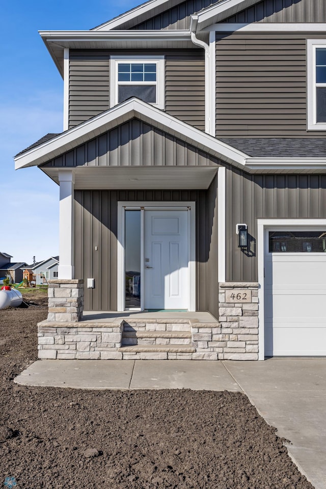 8378 62nd St S, Horace, ND 58047 - entrance to property featuring board and batten siding, stone siding, and a garage