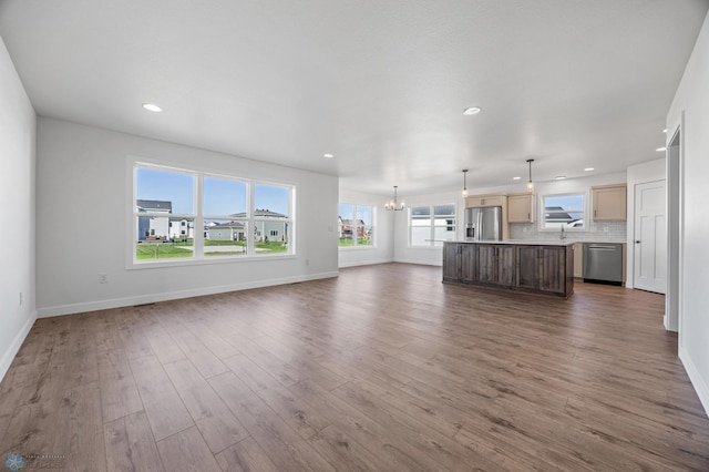 8378 62nd St S, Horace, ND 58047 - unfurnished living room featuring a chandelier, baseboards, wood finished floors, and recessed lighting