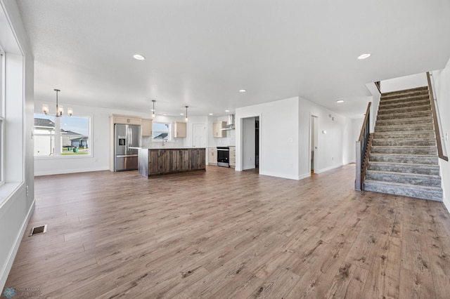 8378 62nd St S, Horace, ND 58047 - unfurnished living room with stairs, a chandelier, baseboards, light wood-style flooring, and recessed lighting
