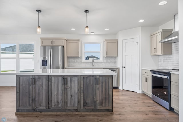 8378 62nd St S, Horace, ND 58047 - kitchen featuring appliances with stainless steel finishes, a sink, decorative backsplash, light countertops, and a kitchen island
