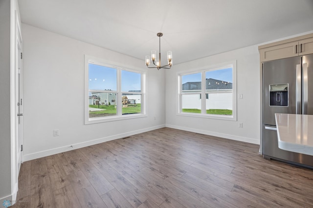8378 62nd St S, Horace, ND 58047 - unfurnished dining area featuring a chandelier, wood finished floors, and baseboards