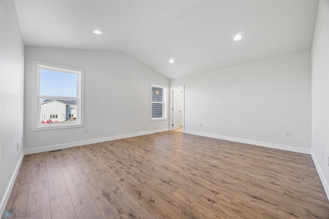 8378 62nd St S, Horace, ND 58047 - spare room with wood-type flooring, vaulted ceiling, baseboards, and recessed lighting