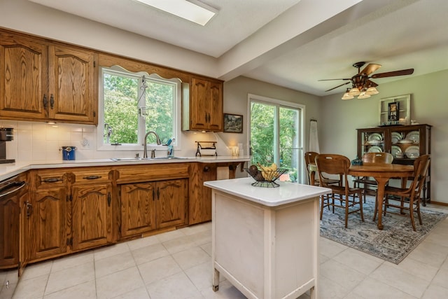 8935 180th St W, Faribault, MN 55021 - kitchen featuring a sink, light countertops, brown cabinets, and tasteful backsplash