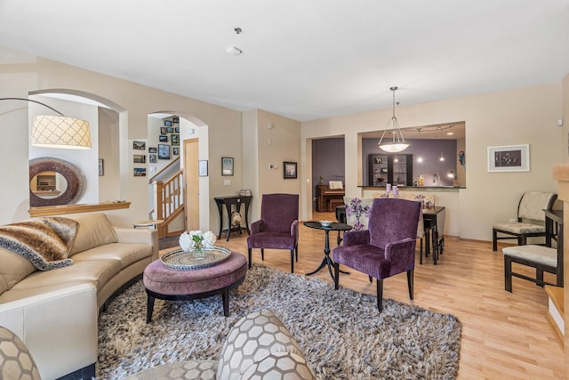 198 Elm St, Saint Paul, MN 55102 - living area featuring light wood-style floors, stairs, baseboards, and arched walkways