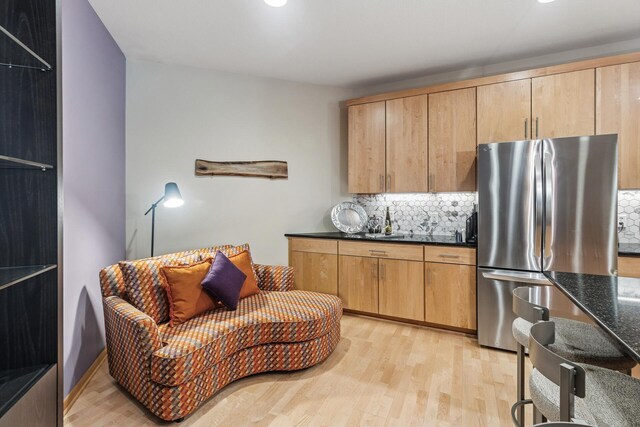 198 Elm St, Saint Paul, MN 55102 - kitchen with freestanding refrigerator, backsplash, light wood-type flooring, and dark stone countertops
