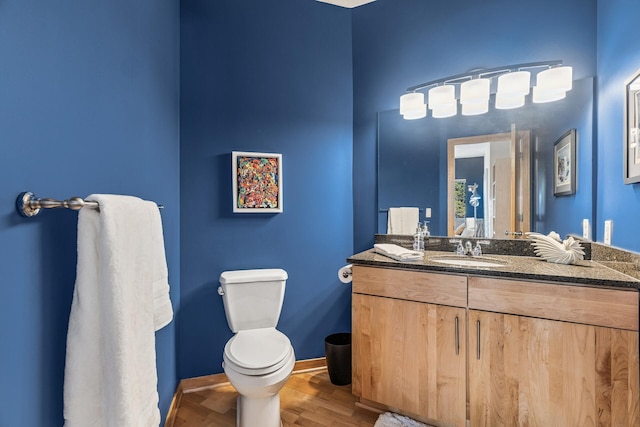 198 Elm St, Saint Paul, MN 55102 - half bathroom with vanity, toilet, wood finished floors, and baseboards