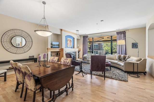 198 Elm St, Saint Paul, MN 55102 - dining room with light wood finished floors, a fireplace, and baseboards