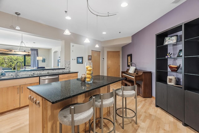 198 Elm St, Saint Paul, MN 55102 - kitchen featuring stainless steel dishwasher, light wood-type flooring, a sink, a breakfast bar area, and a center island