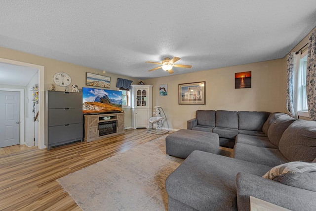 1858 Kennedy Ct, Northfield, MN 55057 - living room featuring light wood finished floors, a ceiling fan, a textured ceiling, and a fireplace