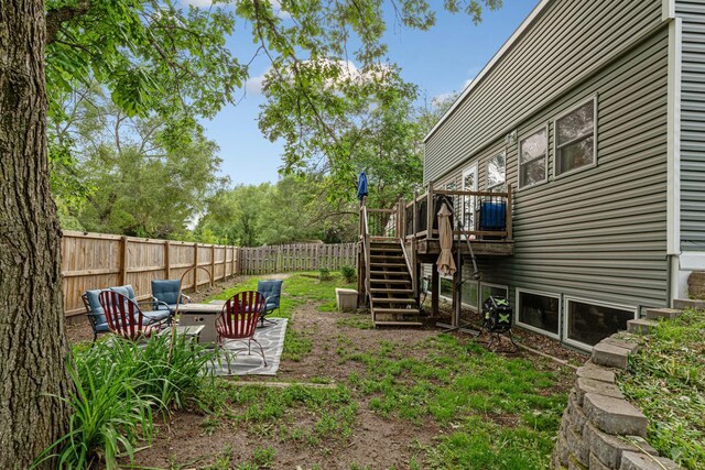 1858 Kennedy Ct, Northfield, MN 55057 - fenced backyard with stairway, a wooden deck, and a patio area