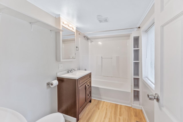 716 15th St NW, Bemidji, MN 56601 - bathroom with wood finished floors, vanity,  shower combination, toilet, and crown molding
