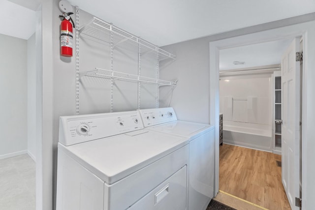716 15th St NW, Bemidji, MN 56601 - laundry area featuring washer and dryer, light wood finished floors, and baseboards