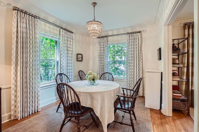 2517 Humboldt Ave S Unit 201, Minneapolis, MN 55405 - dining area featuring hardwood / wood-style floors, healthy amount of natural light, a chandelier, baseboards, and crown molding