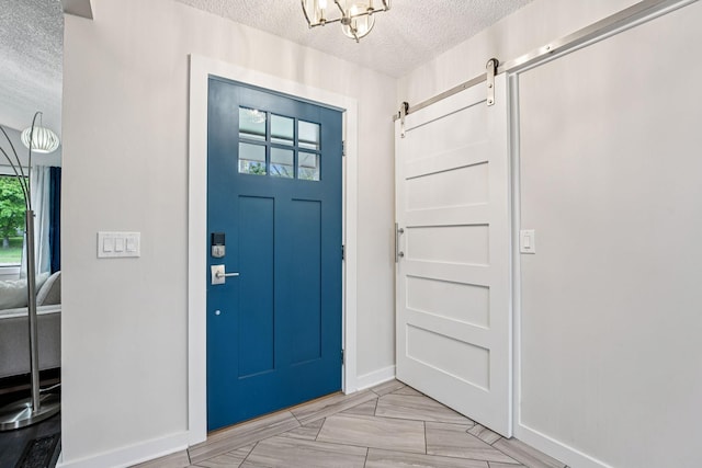 538 Silver Lake Rd NW, New Brighton, MN 55112 - foyer entrance featuring a textured ceiling, a chandelier, baseboards, and a barn door