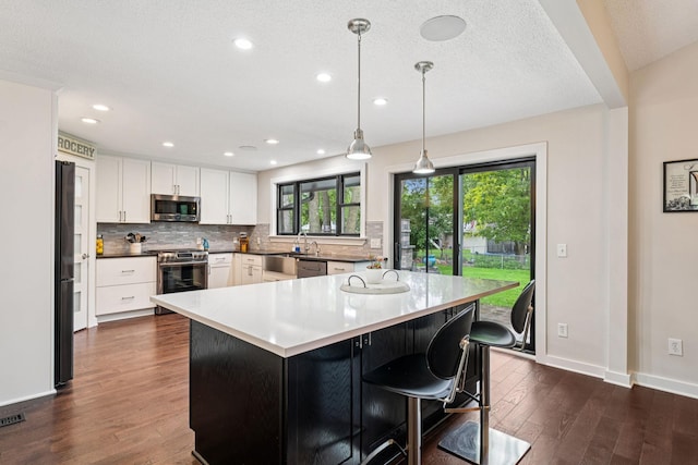 538 Silver Lake Rd NW, New Brighton, MN 55112 - kitchen with appliances with stainless steel finishes, dark wood-style floors, decorative backsplash, white cabinetry, and baseboards