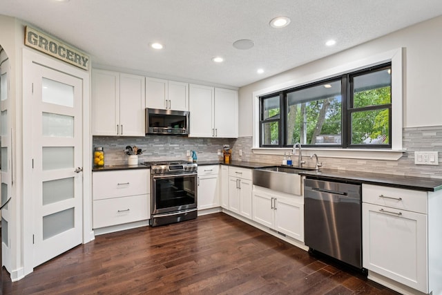 538 Silver Lake Rd NW, New Brighton, MN 55112 - kitchen with appliances with stainless steel finishes, a sink, dark countertops, dark wood finished floors, and recessed lighting