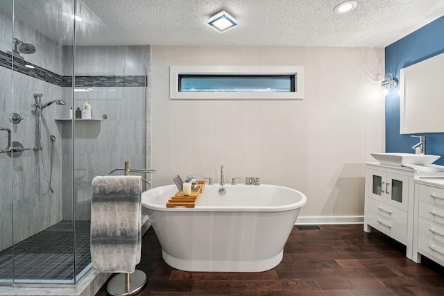 538 Silver Lake Rd NW, New Brighton, MN 55112 - full bath with wood finished floors, a soaking tub, vanity, a shower stall, and a textured ceiling