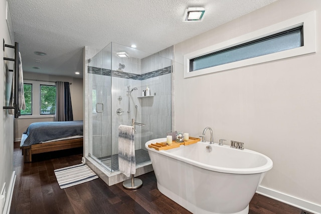538 Silver Lake Rd NW, New Brighton, MN 55112 - ensuite bathroom featuring a freestanding bath, wood finished floors, a stall shower, a textured ceiling, and baseboards
