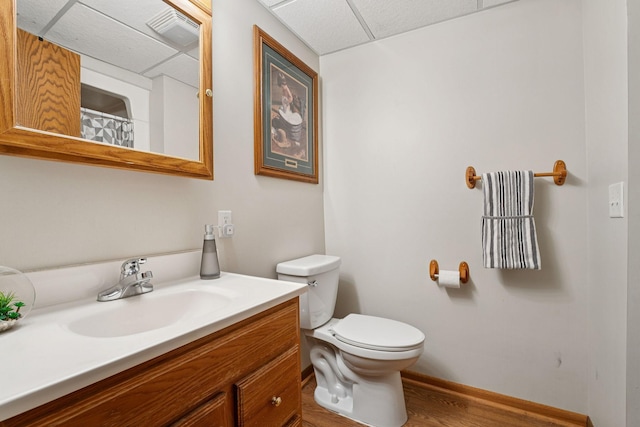 538 Silver Lake Rd NW, New Brighton, MN 55112 - bathroom with a drop ceiling, vanity, toilet, wood finished floors, and baseboards