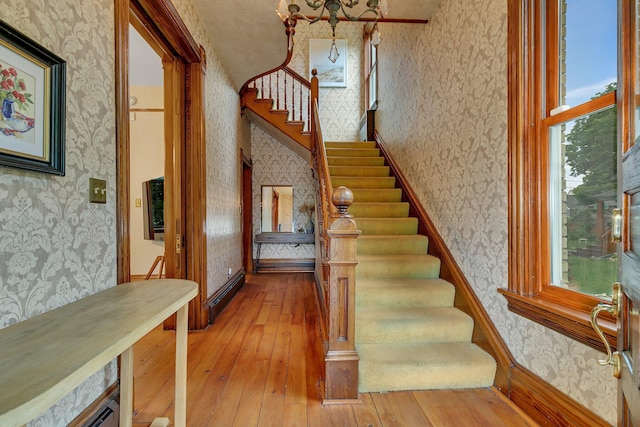 605 7th Ave N, Saint Cloud, MN 56303 - stairs featuring wallpapered walls, wood-type flooring, healthy amount of natural light, baseboards, and a baseboard heating unit