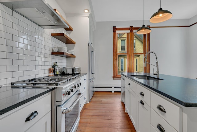 605 7th Ave N, Saint Cloud, MN 56303 - kitchen featuring high quality appliances, a sink, wall chimney exhaust hood, dark countertops, and a baseboard radiator