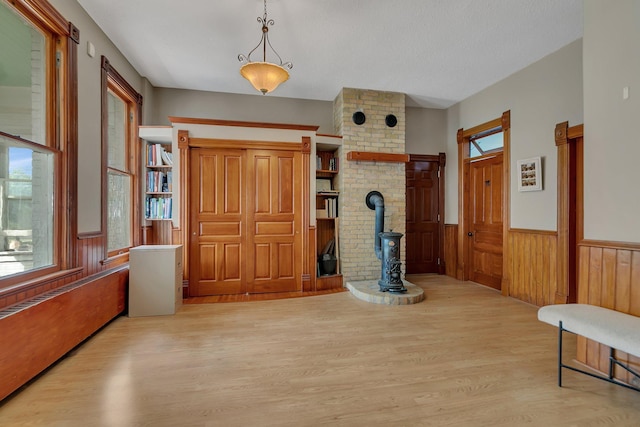 605 7th Ave N, Saint Cloud, MN 56303 - foyer featuring wood finished floors, wainscoting, a wood stove, and wood walls
