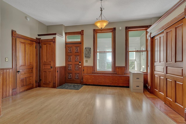 605 7th Ave N, Saint Cloud, MN 56303 - foyer entrance with wainscoting, light wood-type flooring, a textured ceiling, and wood walls