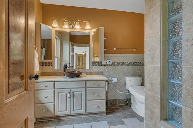 605 7th Ave N, Saint Cloud, MN 56303 - bathroom featuring vanity, tile walls, toilet, and tile patterned flooring