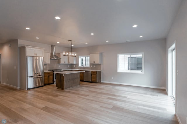 4174 Arthur Dr S, Fargo, ND 58104 - kitchen with appliances with stainless steel finishes, wall chimney range hood, a sink, a kitchen island, and baseboards