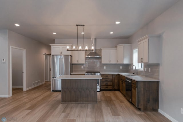 4174 Arthur Dr S, Fargo, ND 58104 - kitchen with stainless steel appliances, wall chimney exhaust hood, light wood-style floors, light countertops, and recessed lighting