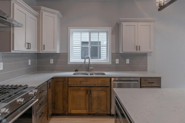 4174 Arthur Dr S, Fargo, ND 58104 - kitchen with a sink, wall chimney range hood, appliances with stainless steel finishes, and white cabinetry