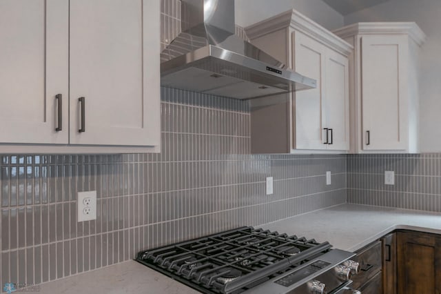4174 Arthur Dr S, Fargo, ND 58104 - kitchen with wall chimney range hood, stainless steel gas stove, tasteful backsplash, and white cabinets